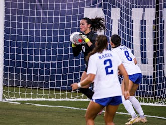 Kat Rader (2) and Elle Piper (8) look on as goalkeeper Leah Freeman (0) saves a shot during Duke's win against West Virginia.