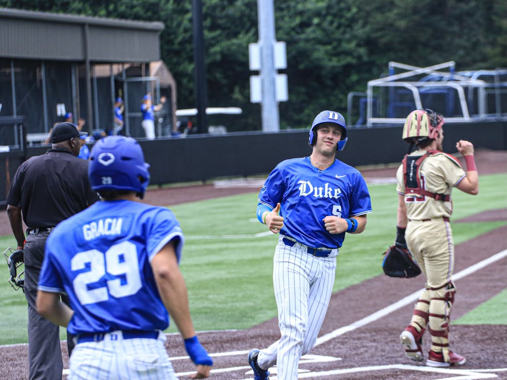 Senior catcher Alex Stone crosses the plate for the Blue Devils.