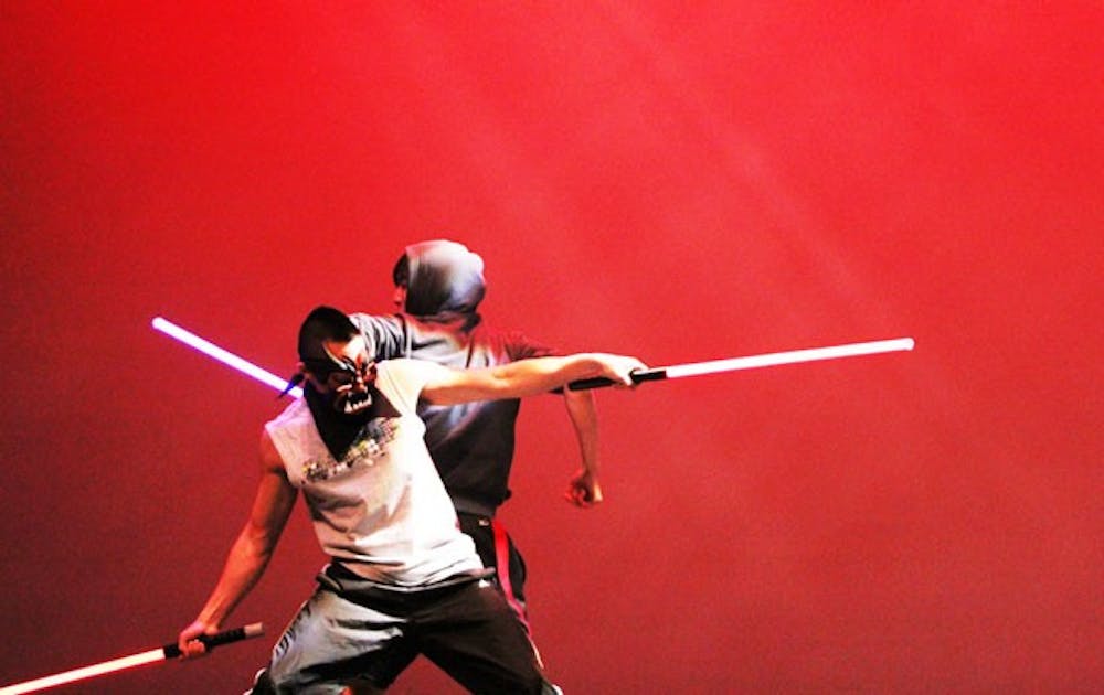 Two students perform comedic martial arts with lightsabers at the Lunar New Year celebration in Page Auditorium Saturday night.