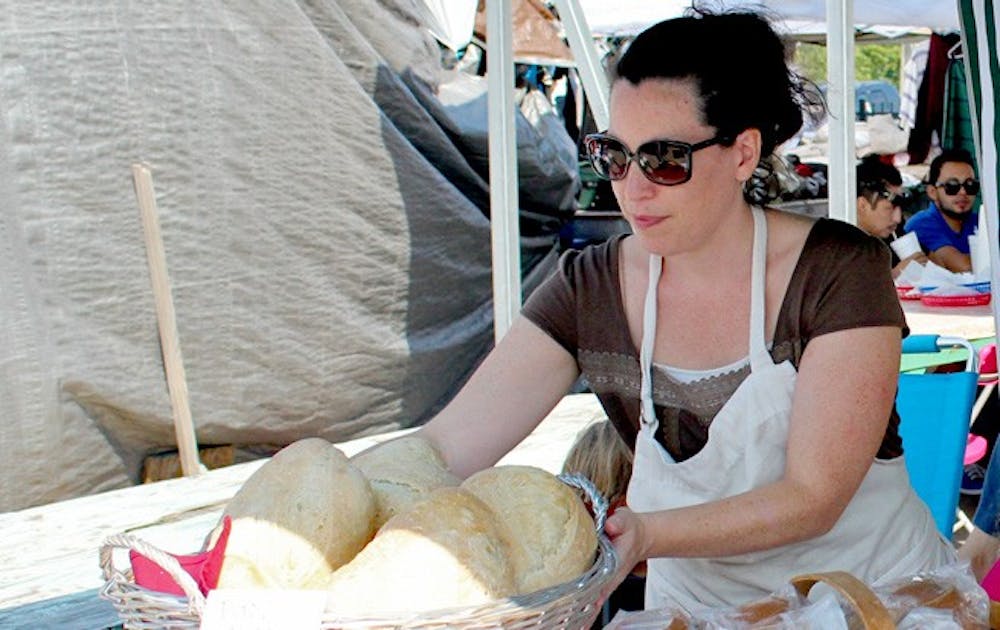 Javiera Caballero, a baker at Durham’s Bread Uprising, presents the bakery’s products at Green Flea market.