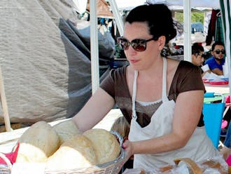 Javiera Caballero, a baker at Durham’s Bread Uprising, presents the bakery’s products at Green Flea market.