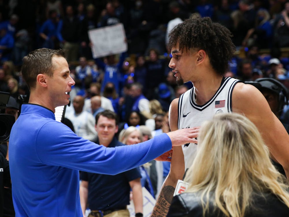 Dereck Lively II (right) with head coach Jon Scheyer after a career night Feb. 4 against North Carolina.