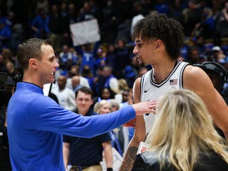Dereck Lively II (right) with head coach Jon Scheyer after a career night Feb. 4 against North Carolina.