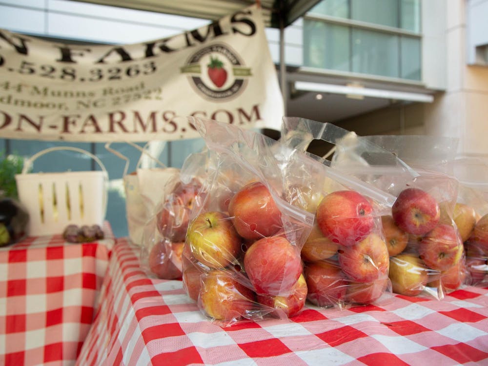 <p>Bags of apples sit at a Duke Farmers Market booth.</p>
