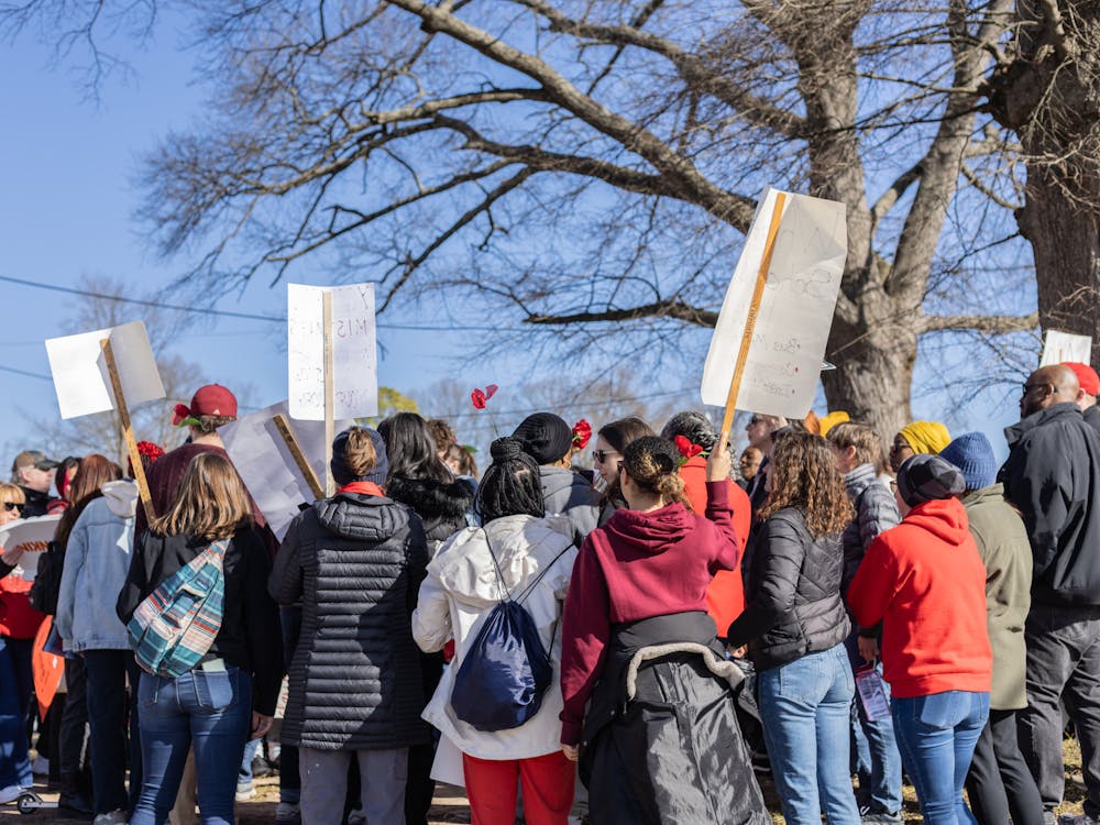 <p>Protestors gather in groups by the Durham public school they represent.</p>