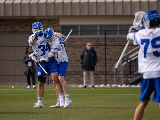 Brennan O'Neill (left) and Dyson Williams (middle) celebrate with Josh Zawada (right) during Duke's win against St. Joseph's.