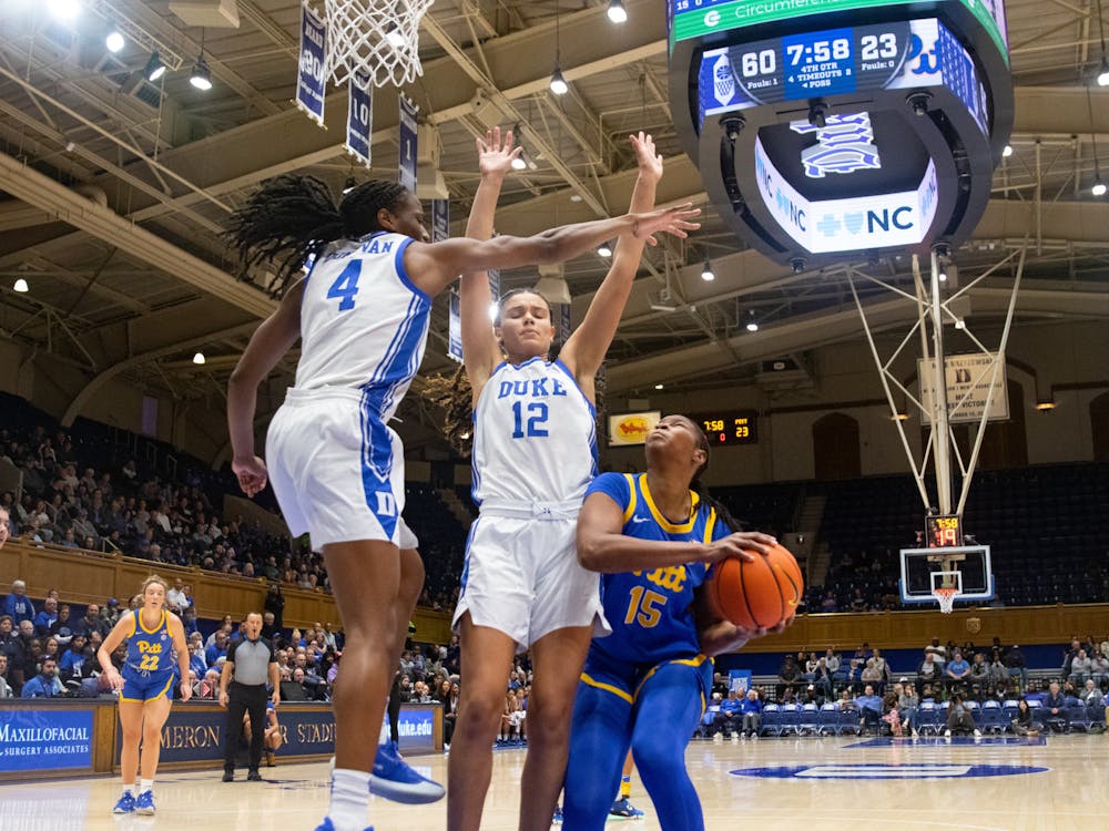 Jadyn Donovan and Delaney Thomas defend a shot attempt from Khadija Faye. 