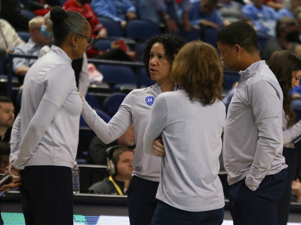 Kara Lawson (center) is losing associate head coach Winston Gandy (right) from her staff.