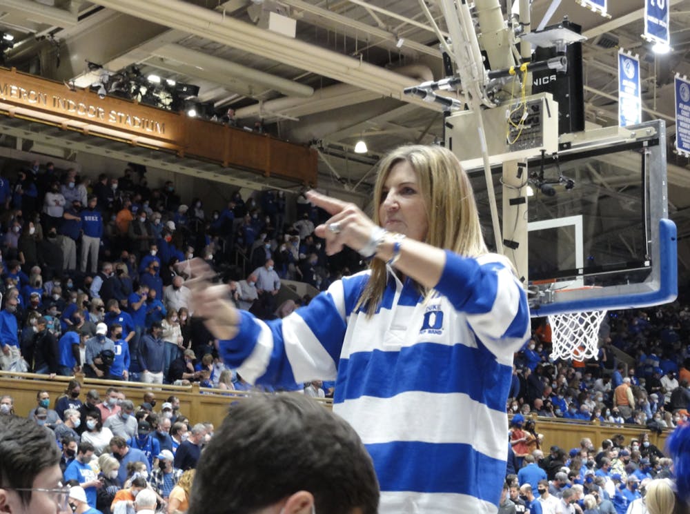 Anne Dowling, Trinity '92, conducts the band at Duke men's basketballs home game against Clemson. Courtesy of DBAA.