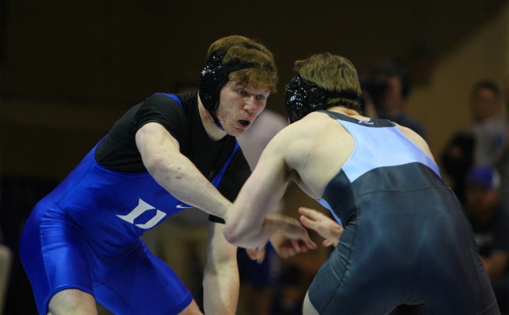 <p>Conner Hartmann has benefited from the guidance of assistant coach Ben Wissel both on and off the mat.</p>