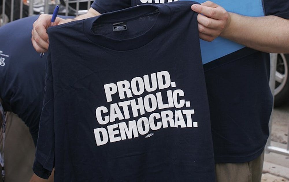An attendee of the Democratic National Convention holds up a shirt that says "Proud. Catholic. Democrat." The party recently revised its platform to include a mention of God, expected to increase Catholic support.