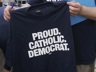 An attendee of the Democratic National Convention holds up a shirt that says "Proud. Catholic. Democrat." The party recently revised its platform to include a mention of God, expected to increase Catholic support.
