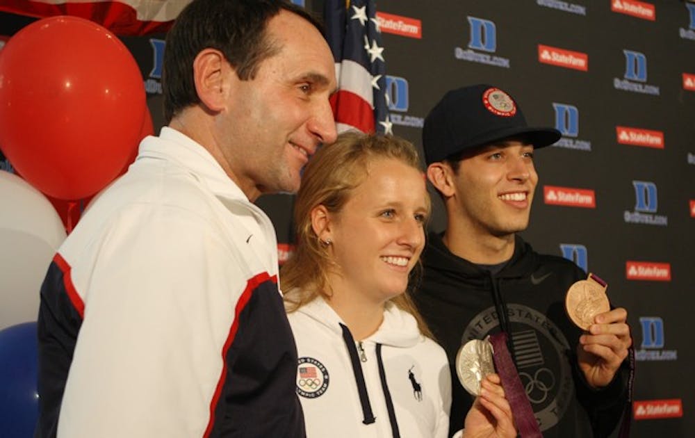 Duke basketball head coach Mike Krzyzewski and Blue Devil divers Abby Johnston and Nick McCrory posed at Raleigh-Durham International Airport last week upon returning from the 2012 Olympic Games in London.