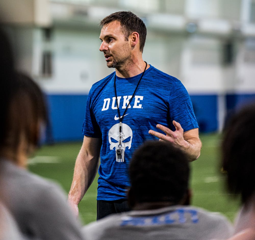 Director of football performance David Feeley speaks to the team during a practice.