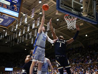 Duke men's basketball's Kyle Filipowski scores over Notre Dame's JJ Starling Tuesday night.
