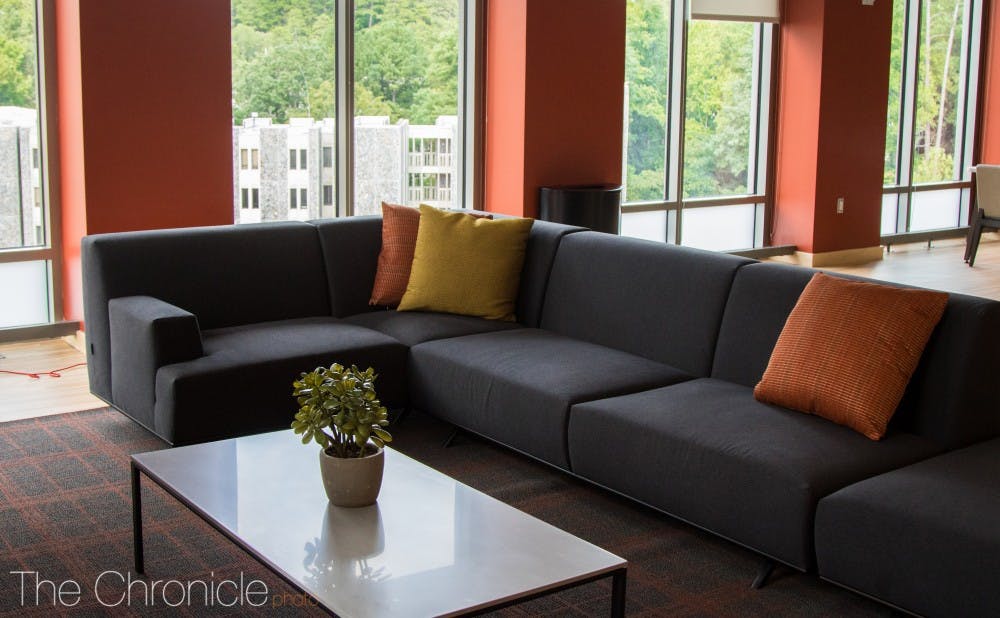 A common area space inside the Hollows has elongated couches and views of Edens Quadrangle. 