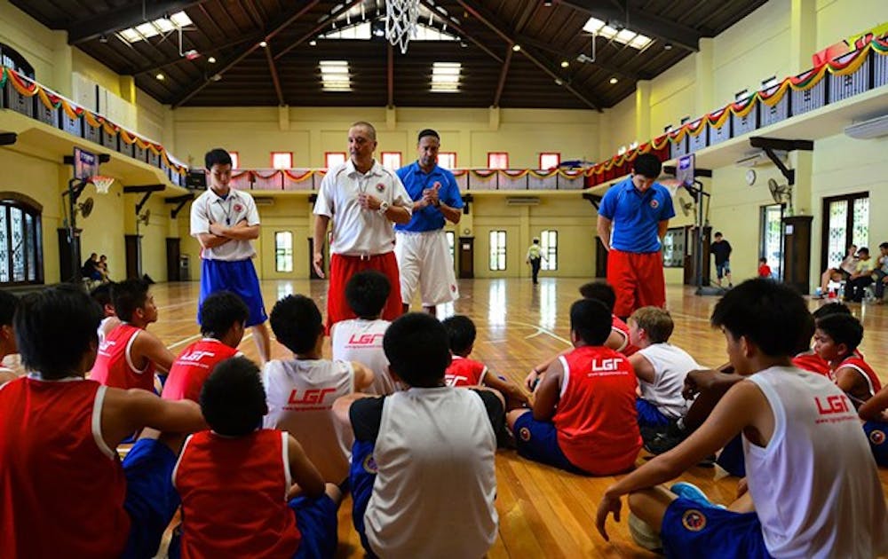 Phil Henderson, in the blue shirt at center, spent the final year of his life in the Philippines opening and running a basketball camp for kids from five to 18 years old. This caption originally said Chris Henderson. The Chronicle regrets the error.