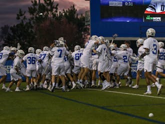 Duke players storm the field after Brennan O'Neill's game-winning goal in overtime Friday.