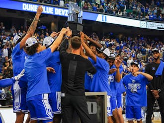 Duke lifts the ACC tournament trophy after defeating Virginia 59-49 in the finals. 