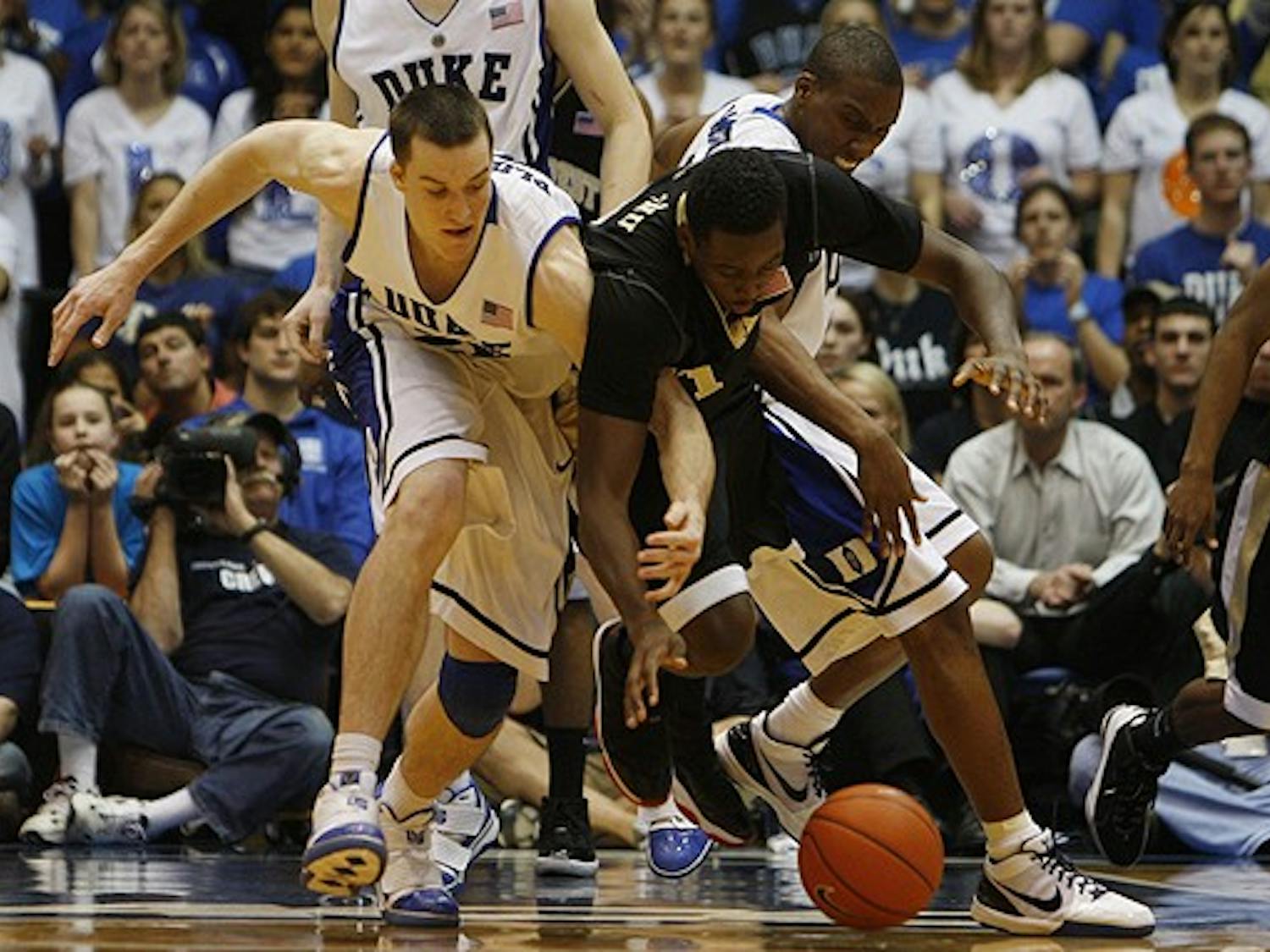 Duke’s Miles Plumlee (left) and Wake Forest’s Al-Farouq Aminu (right), the key figures of Sunday’s contest between the two ACC rivals, battle for a loose ball during the Blue Devils’ 90-70 win in Cameron Indoor Stadium.