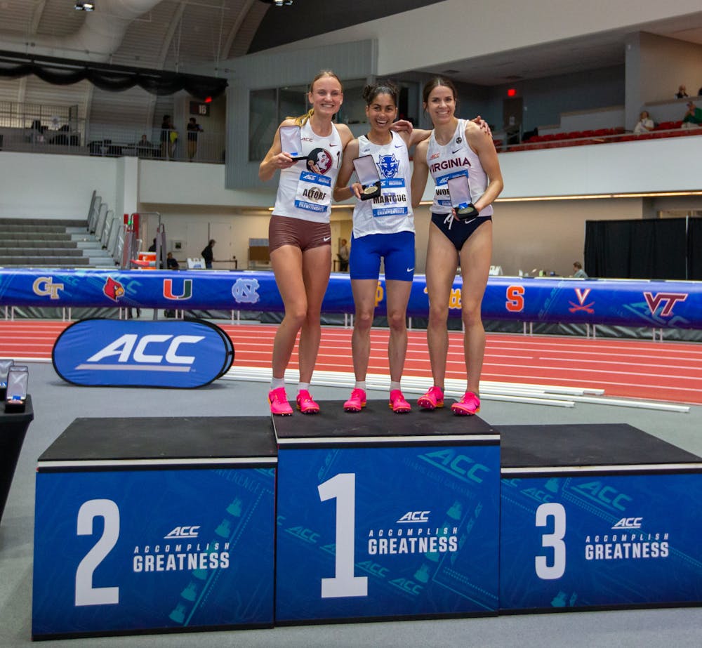 Amina Maatoug (middle) stands on the podium after finishing first in the women's mile at the ACC Championships.