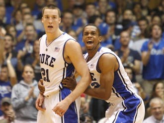 Lance Thomas (right) celebrates after Miles Plumlee (left) stole the ball and dunked it home in the first half of Duke’s win over Charlotte.