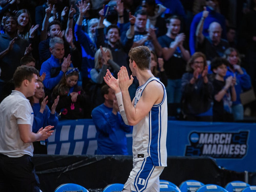 <p>Kyle Filipowski applauds the Blue Devil fans as he heads off the court.</p>