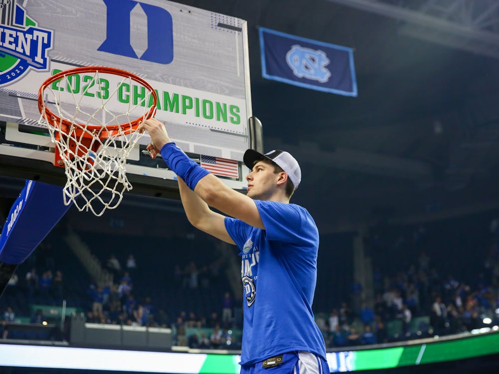 Kyle Filipowski cuts the net after being named ACC tournament MVP. 