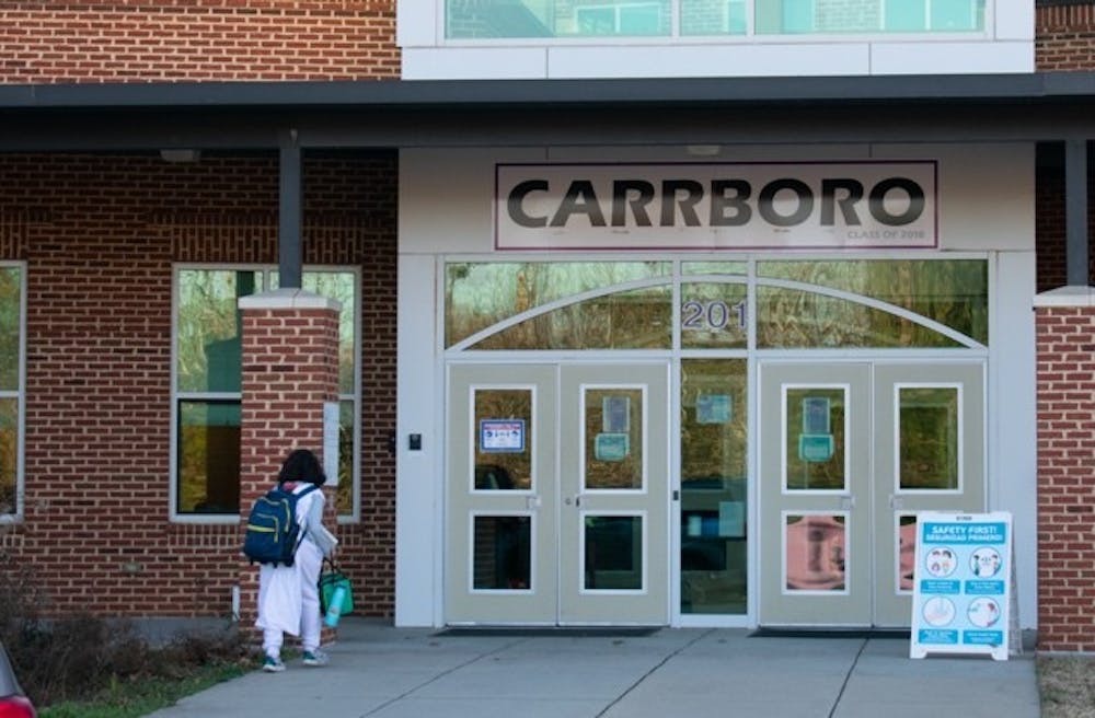 A student enters Carrboro High School on Friday, Jan. 7, 2022. 