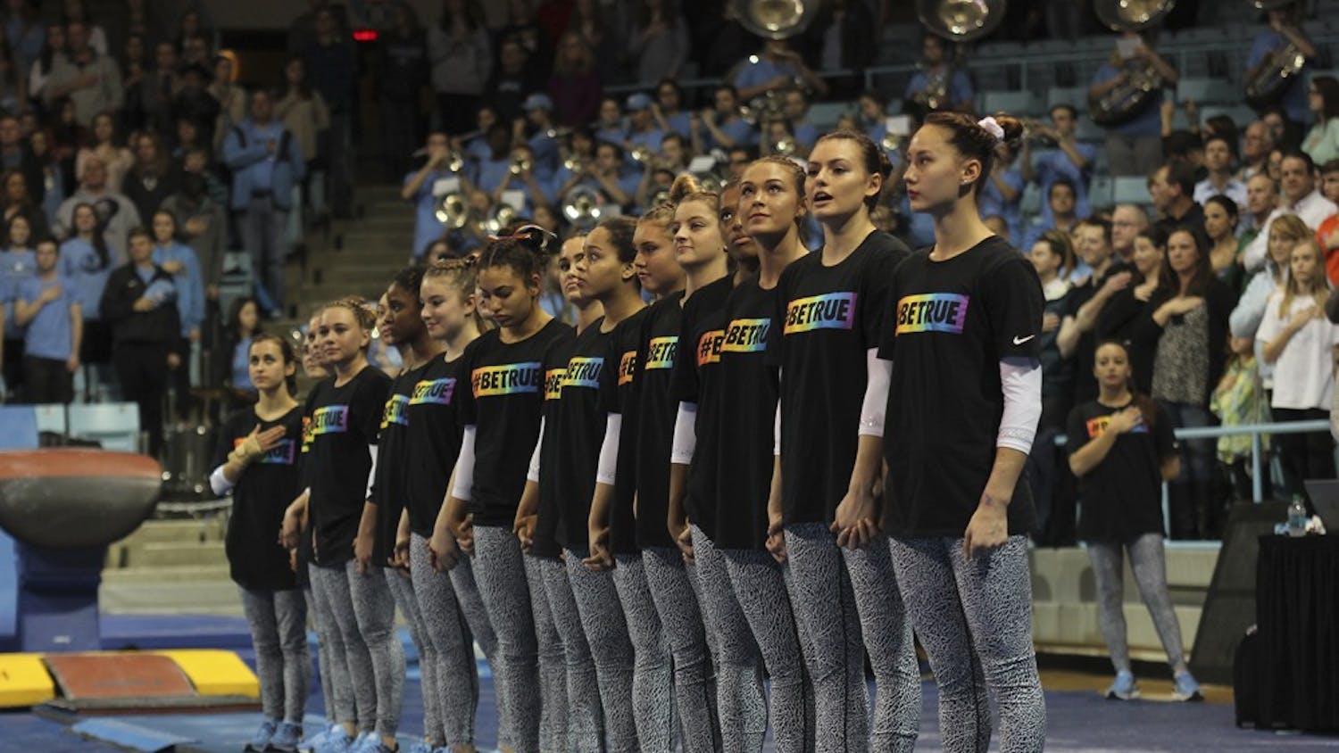 The gymnastics team stands together wearing shirts with the saying “#BeTrue” in honor of the LBGTQ movement before their meet against Florida on Friday.