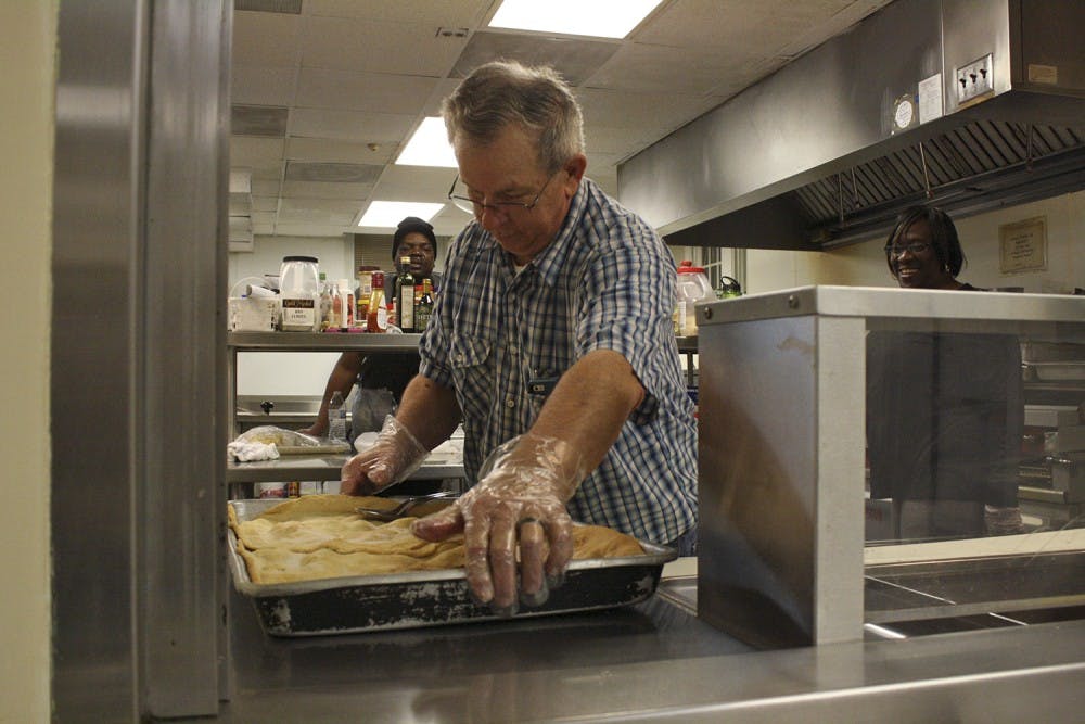 Alvin Alston sets out some peach cobbler before "Meet Me in the Kitchen", an event hosted by the IFC that works to feed those who need help in the Chapel Hill community. He has worked in the community kitchen for the past 12 years. 