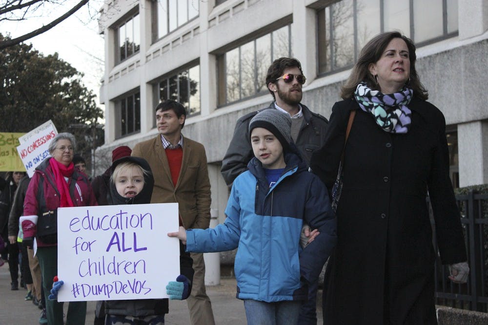 From left: Colin, Christopher, and Marty Long protest the nomination of Betsy DeVos for United States' Secretary of Education
"We are here because DeVos is a terrible idea for Secretary of Education." "As a mother, my child is not receiving the best education, and not all children are receiving the best education."
