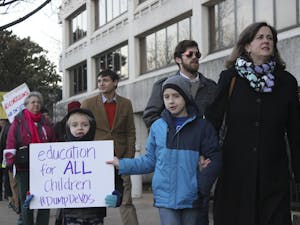 From left: Colin, Christopher, and Marty Long protest the nomination of Betsy DeVos for United States' Secretary of Education"We are here because DeVos is a terrible idea for Secretary of Education." "As a mother, my child is not receiving the best education, and not all children are receiving the best education."