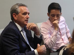 Bubba Cunningham (left), UNC Athletic Director, contributes to discussion at a 2016 meeting of the Faculty Athletics Committee (FAC) while Ezra Baeli-Wang, a student athlete advisory council representative, listens intently.
