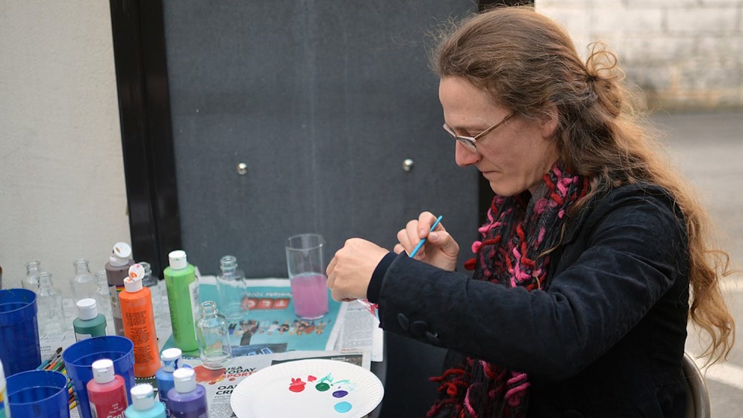 Sarah Wolfe, a resident of Durham, enjoys painting a glass bottle at Lantern Restaurant. She is a curator for Windows in the Chapel Hill area.