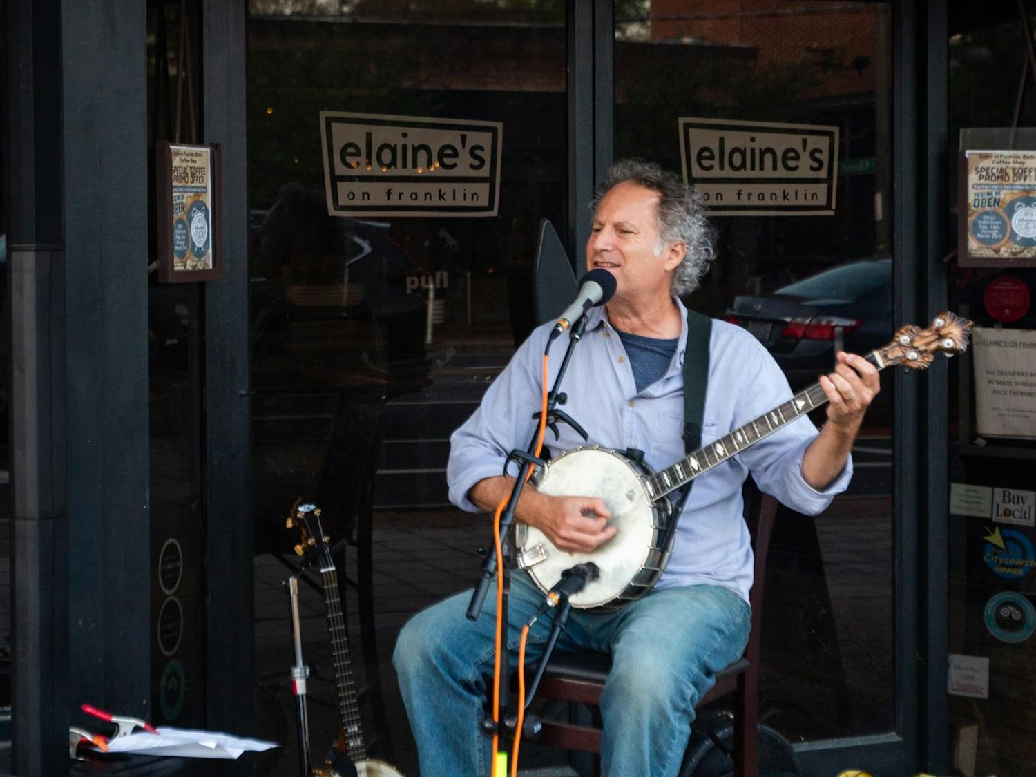 Street performer Cary Moskovitz plays the banjo outside of Elaine's Restaurant on Franklin Street in Chapel Hill, N.C. on Saturday, April 1, 2023. The performance was part of the Downtown Live series, which features local musicians in outdoor settings in downtown Chapel Hill.