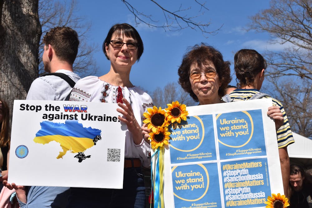 <p>Maryana Kapustina, research associate professor at the UNC School of Medicine, and alumna Donna Goldstein hold up signs in solidarity with Ukraine at a campus rally on Thursday, Mar. 3, 2022. "We hope for a peaceful end to this war. In the meantime, support Ukraine any way you can," Goldstein said.</p>