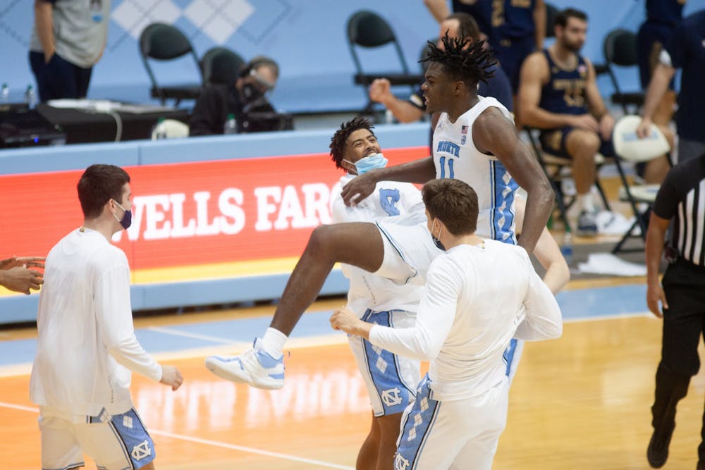 UNC first year forward Day'Ron Sharpe (11) celebrates with KJ Smith and Walker Miller following Carolina's 66-65 win over Notre Dame at the Dean E. Smith Center, January 2nd, 2021.