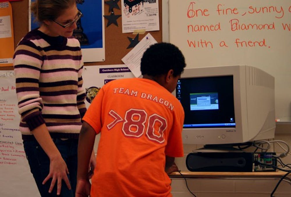 Alexandra Cordero shows Phillips Middle School sixth-grader Jason Satterfield his new computer. DTH/Laura Melosh