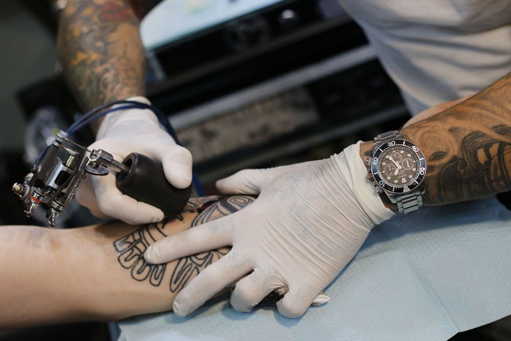 <p>Tattoo artist Mike Wheeler begins shading the Alaskan tribal tattoo on Hayden Fitzgerald's forearm Monday&nbsp;at Glenn's Tattoo Service.</p>