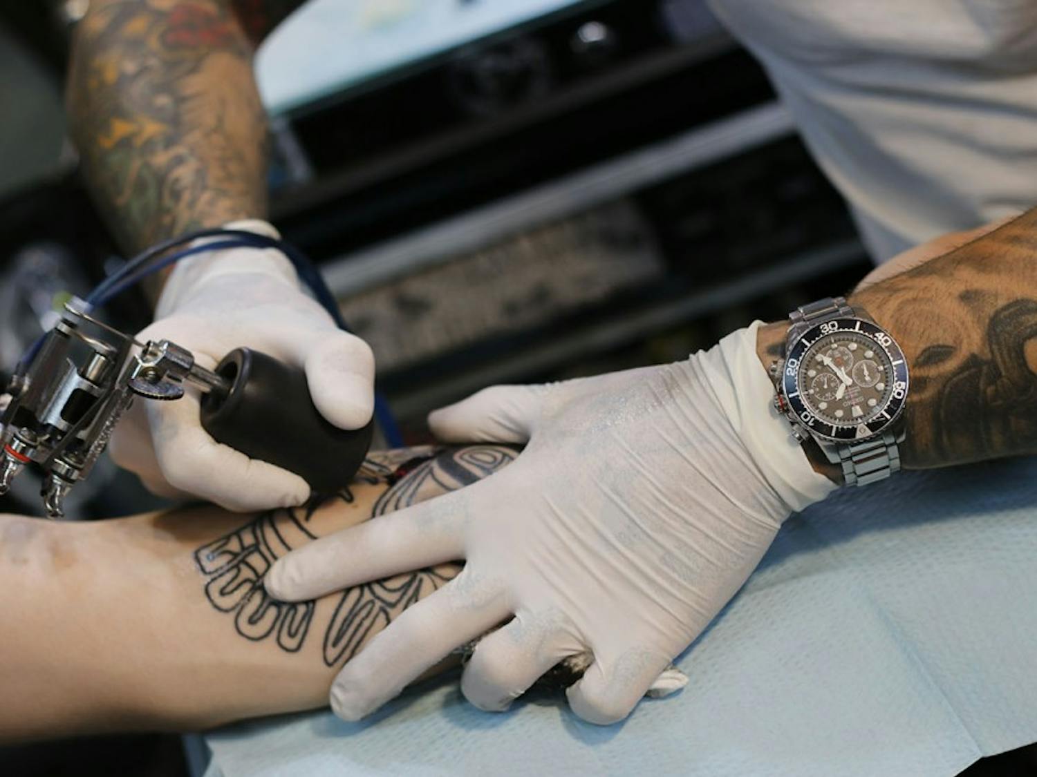 Tattoo artist Mike Wheeler begins shading the Alaskan tribal tattoo on Hayden Fitzgerald's forearm Monday&nbsp;at Glenn's Tattoo Service.