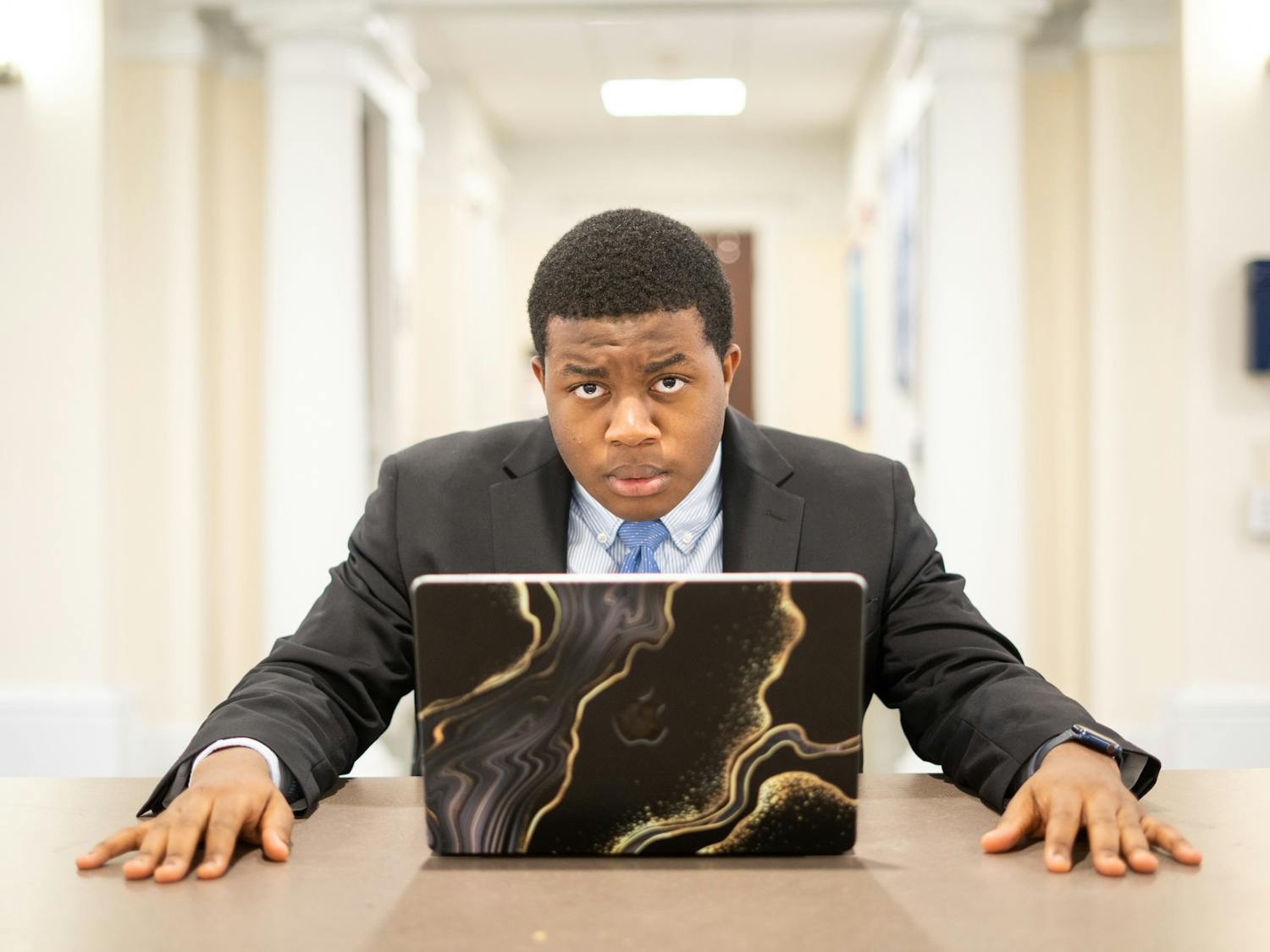 DTH Photo Illustration. UNC first-year Oluwatumininu Oguntola poses frustrated in front of a laptop on Monday, Nov. 21, 2022.