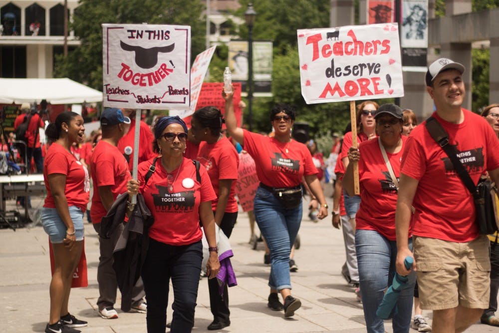 Educators carry signs through Bicentennial Plaza during the rally for education on May 16 in Raleigh.