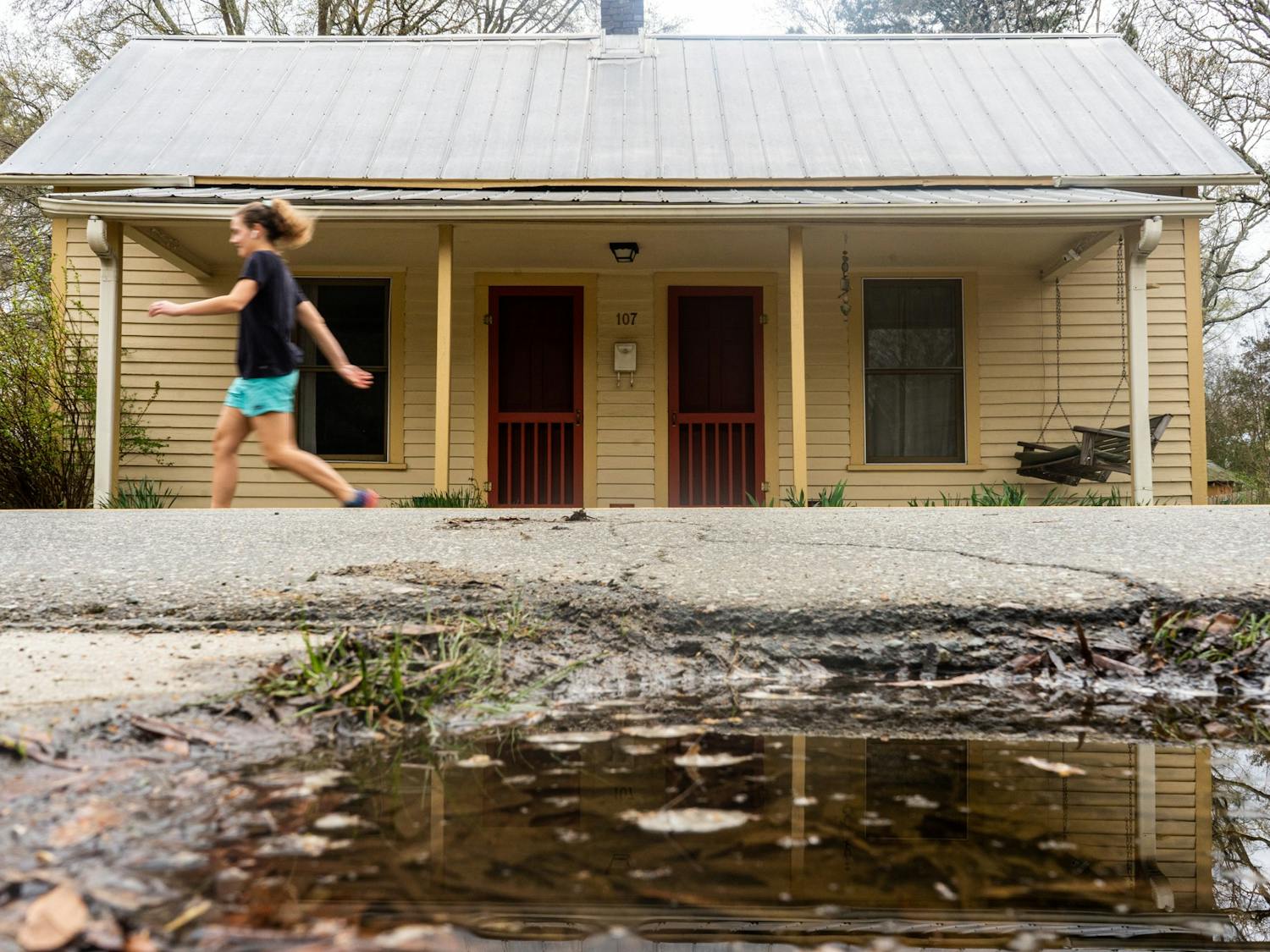 A pedestrian walks in front of a house in Carrboro on Thursday, Mar. 24, 2022. The Carrboro Town Council is debating ways to increase affordable housing in the community.