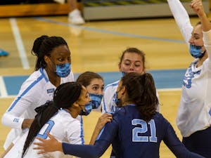 Players on the UNC Womens Volleyball team celebrate during their game against Virginia on Saturday Oct. 31 at Carmichael Arena. The Tar Heels won 3-1.
