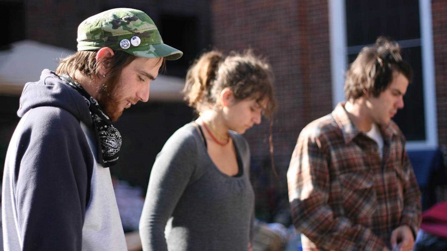 John K., Kassandra Ofray and Kyle Aronstam are thinking of how to arrange the wooden shipping pallats which will help warm Occupy Chapel Hill during the colder winter months. John K. explains, "When it rains concrete doesn't insulate. The wooden platforms are just a prototype." Vincent Gonzalez says that "plans for now are insulation, blankets and wooden shipping pallats. 