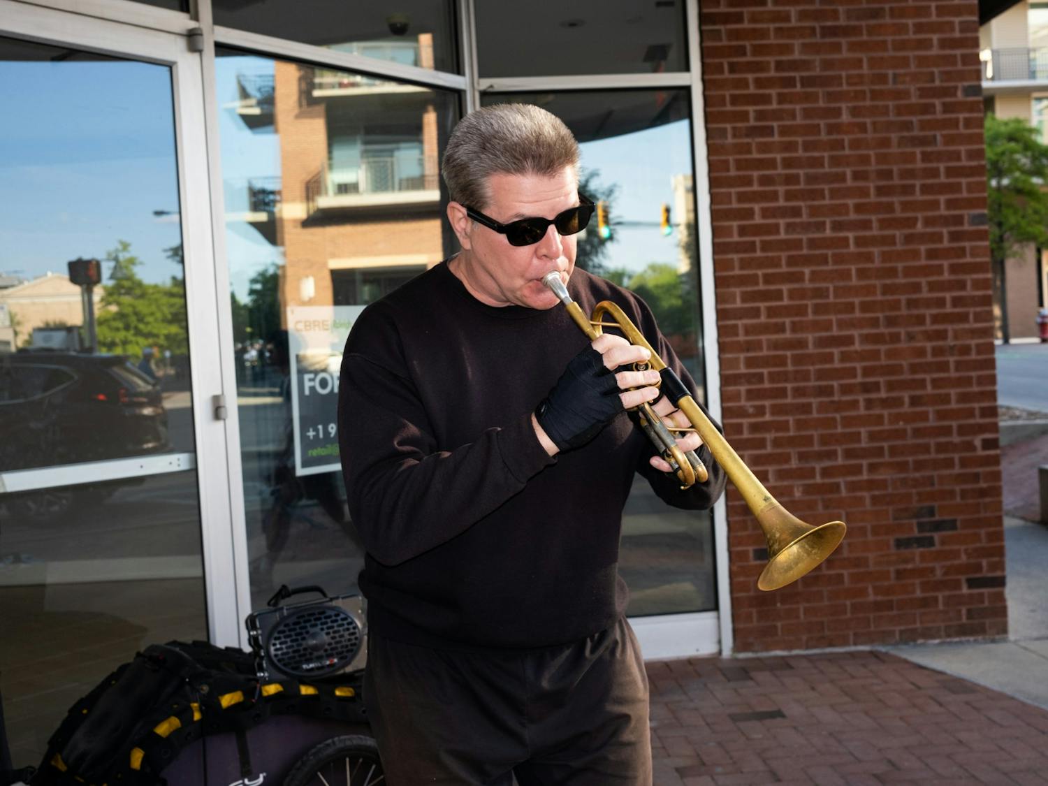 Chris, the trumpet monk, playing his rendition of a Louis Armstrong piece at sunset by the corner of Chapel Hill Florist in Chapel Hill, N.C. on April 25th, 2023.