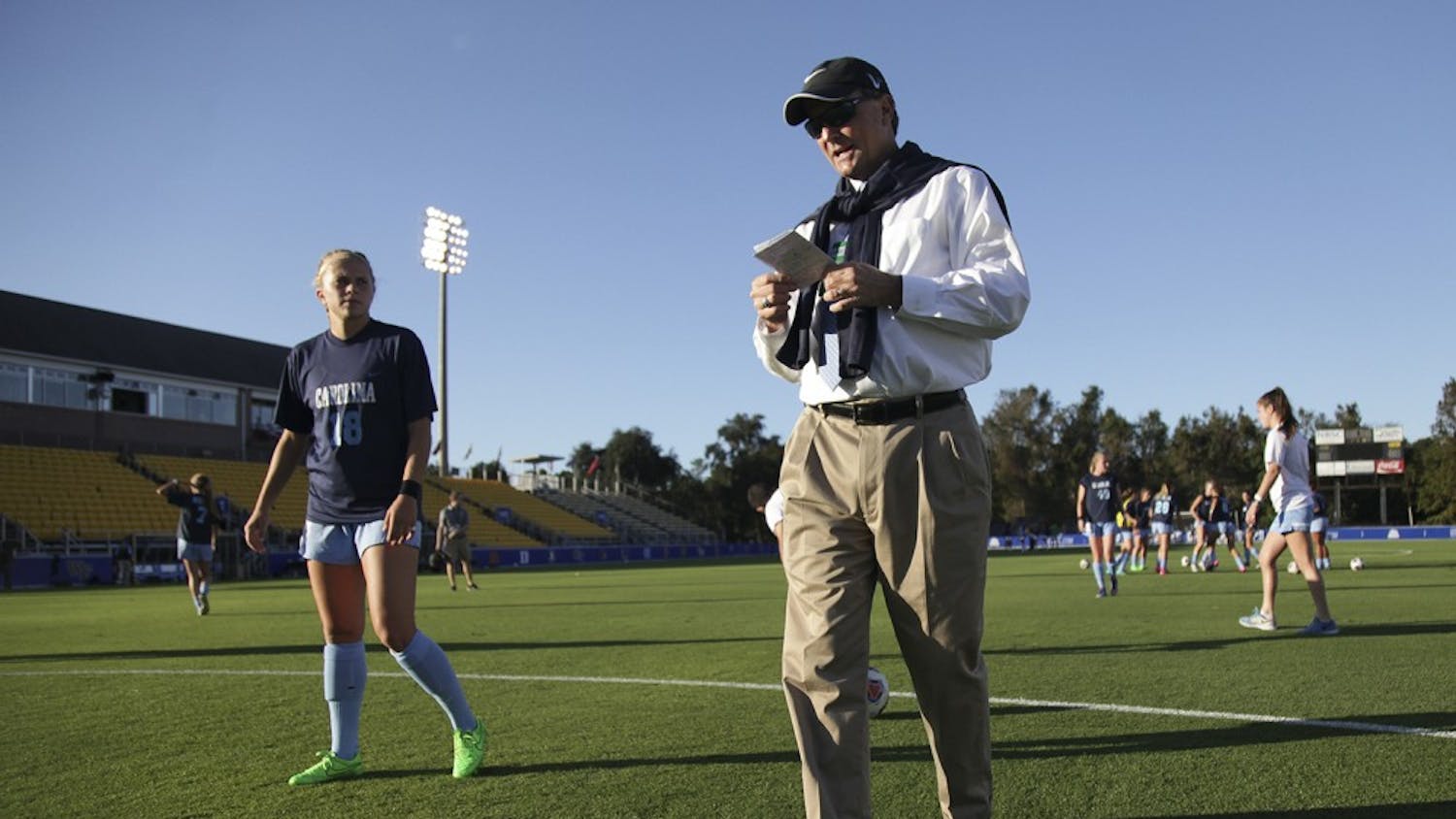 UNC women's soccer head coach Anson Dorrance looks over his notes as he walks around at practice.