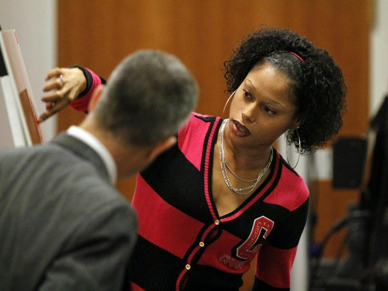 With the assistance of Orange DA James Woodall, Jr, left, prosecution witness Shanita Love, right, the former girlfriend of DeMario Atwater on Friday, Dec. 9, 2011 indicates to the Lovette jury where on an aerial photograph of Durham, NC she witnessed defendant Laurence Alvin Lovette, 21, dispose of three pieces of a semi-auto pistol back in March, 2008. Love was the first witness at the start of the third day of testimony in the Lovette trial for kidnapping, robbery and murder of UNC student body president Eve Carson on March 5, 2008. 
