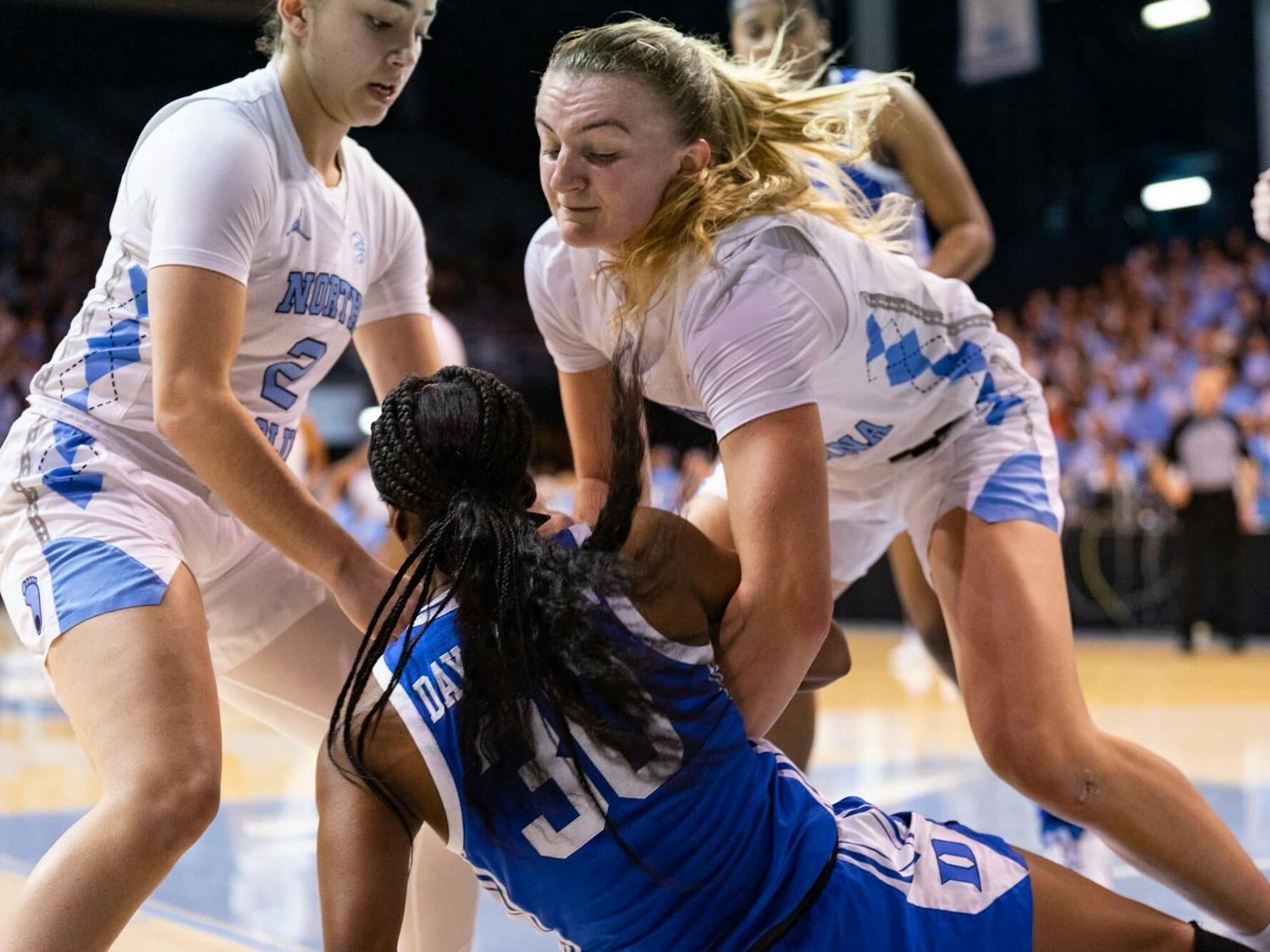 UNC junior guard Alyssa Ustby (1) and UNC freshman guard Paulina Paris (2) fight for the ball during the women’s basketball game against Duke on Thursday, Jan. 19, 2023, at Carmichael Arena.